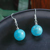 Turquoise bead earrings on a black surface