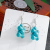 Turquoise beaded earrings on a white card with 'Handmade' text.
