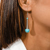 Close-up of a turquoise earring worn by a person with dark hair.