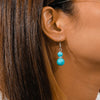Turquoise bead earring worn by a person with brown hair.
