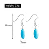 Turquoise earrings with measurements on a white background