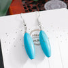 Turquoise earrings on a white card with 'Handmade' text