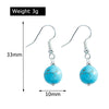 Turquoise bead earrings with measurements and weight on a white background