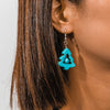 Turquoise earrings worn by a person with brown hair.
